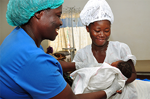 Health worker at a CHAG facility hands a newborn to her mother