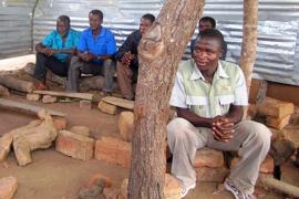 In Angonia, Tete Province, Mozambique, a newly trained community health worker (front right) takes part in a meeting with community leaders. He’s revered as “the son of the community.” Community health workers like him are often able to address the most common causes of death and morbidity in developing countries.