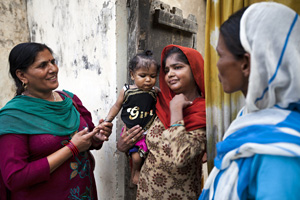 Community health workers assist a mother and her child in India